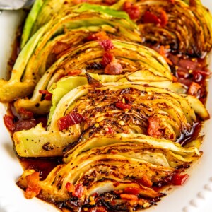 Bacon fried cabbage on a serving platter with serving forks on the side.