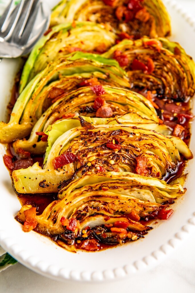 Bacon fried cabbage on a serving platter with serving forks on the side.