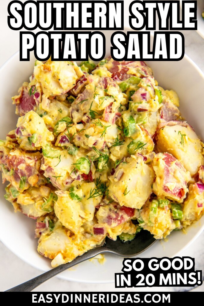 A spoon in a bowl of creamy southern style red potato salad with eggs and fresh dill.