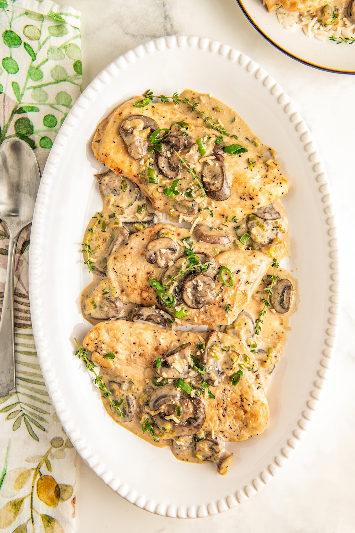 Serving platter filled with juicy and tender chicken and mushrooms in a creamy asiago cheese sauce.