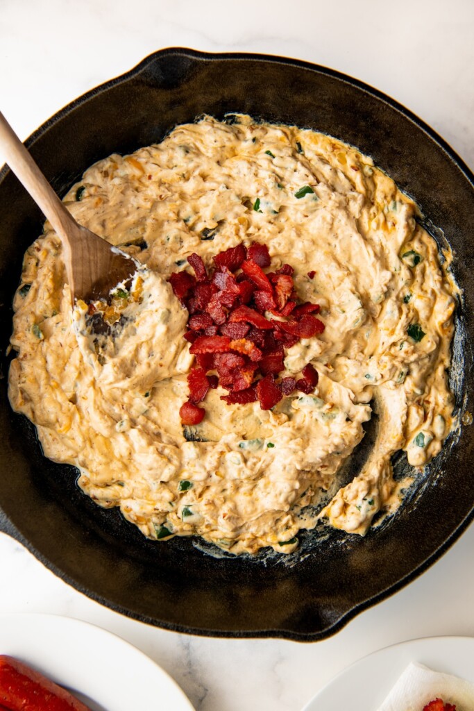 Adding the bacon to the creamy cheese mixture.