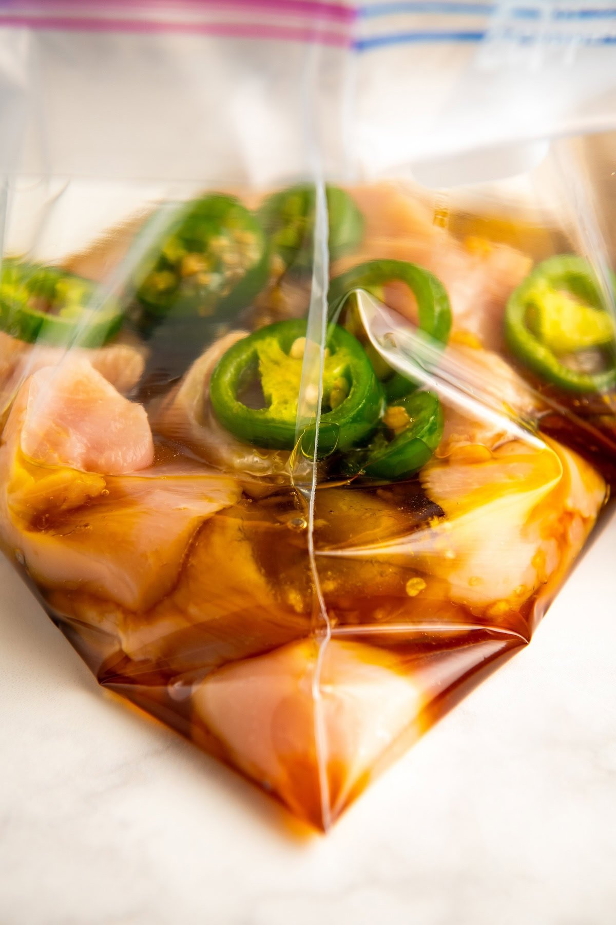 Close-up of the chicken marinade in a Ziploc bag with chicken breasts.