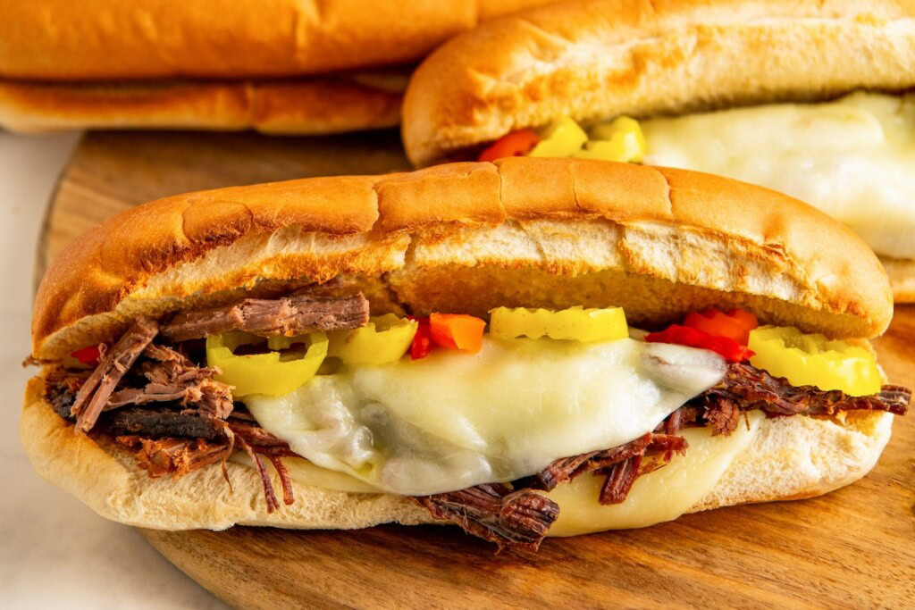 Melted cheese, peppers, and shredded Italian beef are sandwiched together in a toasted hoagie roll. 