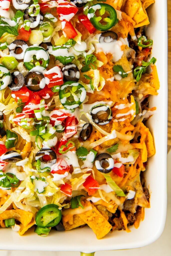 Up close shot of taco casserole with fritos in a baking dish.