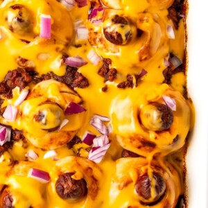 Close-up of the chili hot dog casserole with cheese sauce in the baking dish.