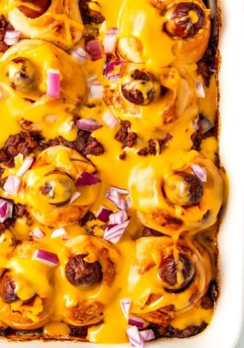 Close-up of the chili hot dog casserole with cheese sauce in the baking dish.