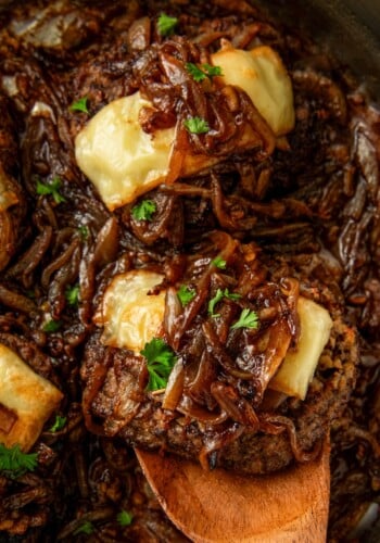 Cube steak and gravy is garnished with fresh herbs.