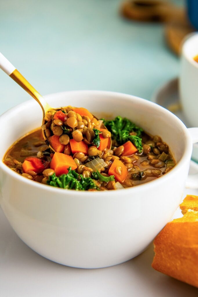 Grabbing a spoonful of homemade lentil soup from the bowl.