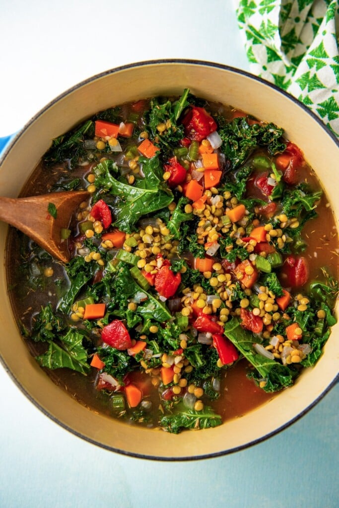 Stirring the pot with lentils, kale, fire-roasted tomatoes, and broth. 