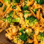 Close-up of fluffy rice with broccoli, onions, and cheddar cheese.