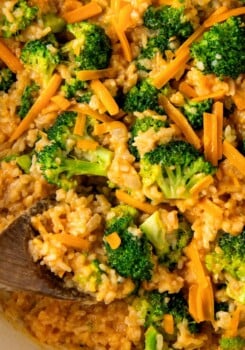 Close-up of fluffy rice with broccoli, onions, and cheddar cheese.