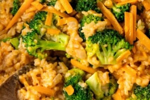 Close-up of fluffy rice with broccoli, onions, and cheddar cheese.