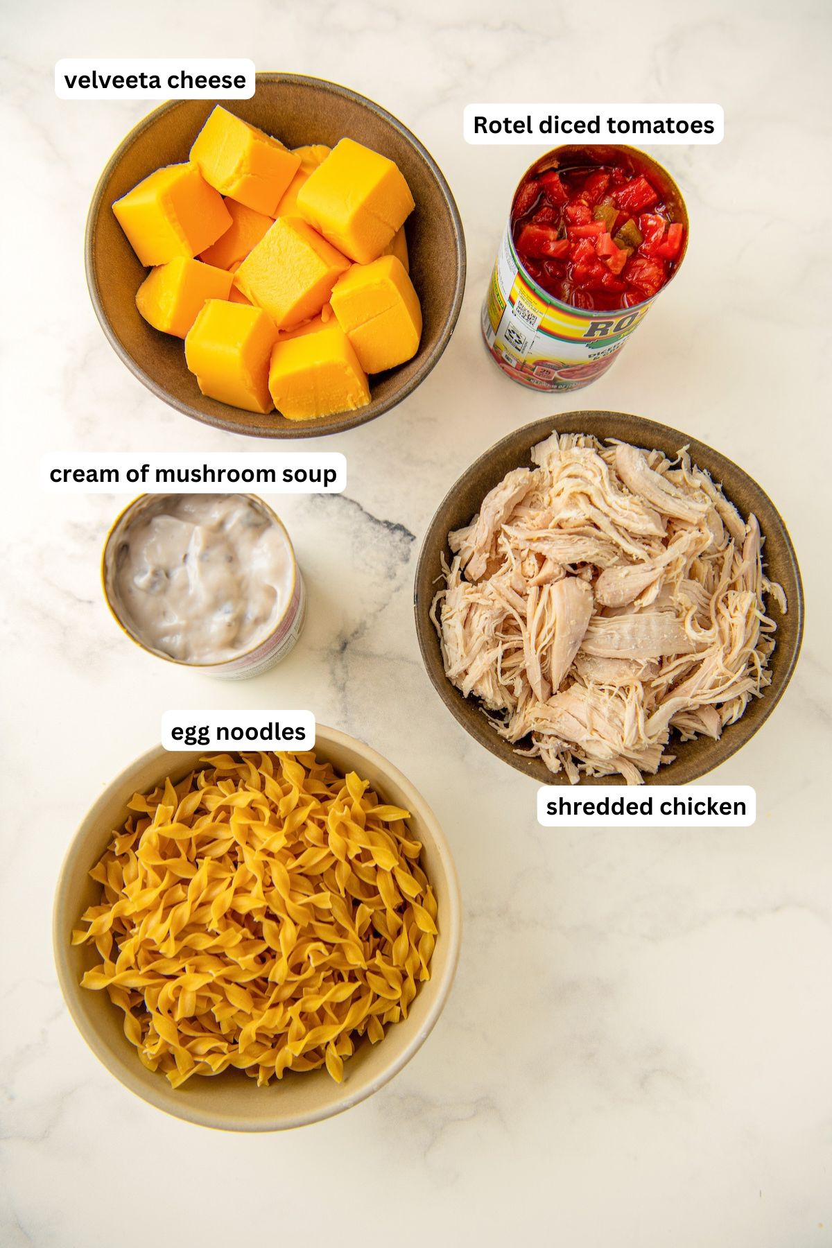 Ingredients for rotel chicken pasta recipe in order from top to bottom: velveeta cheese, rotel, cream of mushroom soup, shredded chicken, egg noodles.