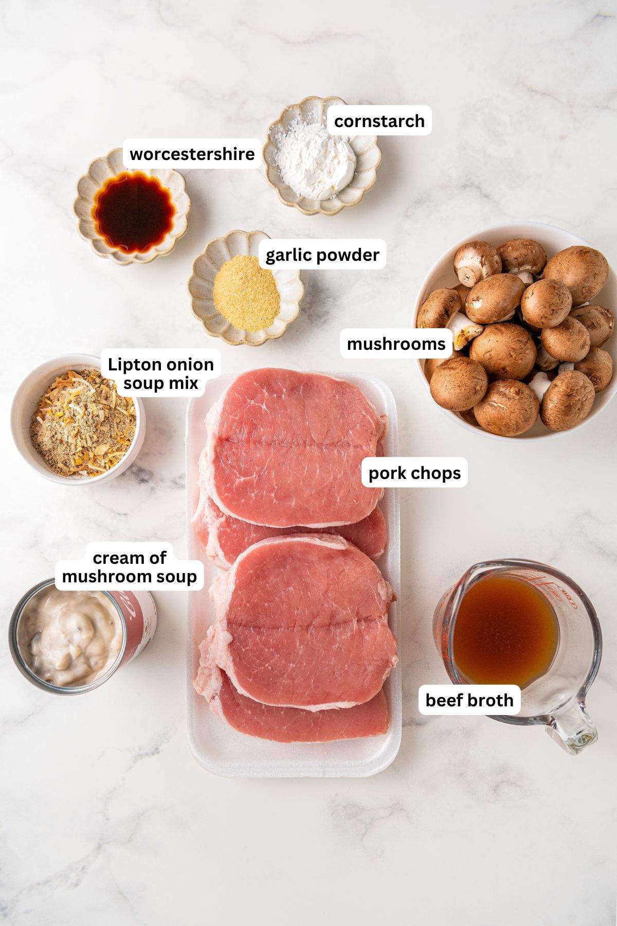 The ingredients for crock pot pork chops recipe in order from top to bottom: worcestershire, cornstarch, garlic powder, lipton onion soup mix, mushrooms, cream of mushroom soup, pork chops, beef broth. 