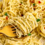 Angel hair pasta is topped with butter, garlic, herbs, and crushed red pepper flakes.