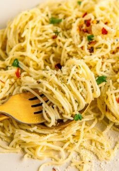 Angel hair pasta is topped with butter, garlic, herbs, and crushed red pepper flakes.