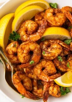 Blackened shrimp served with fresh lemon wedges.