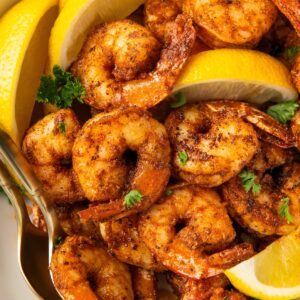 Blackened shrimp served with fresh lemon wedges.