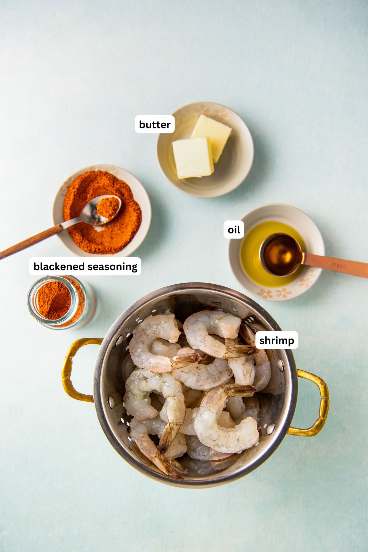 Ingredients for blackened shrimp recipe in order from top to bottom: blackened seasoning, butter, oil, shrimp.