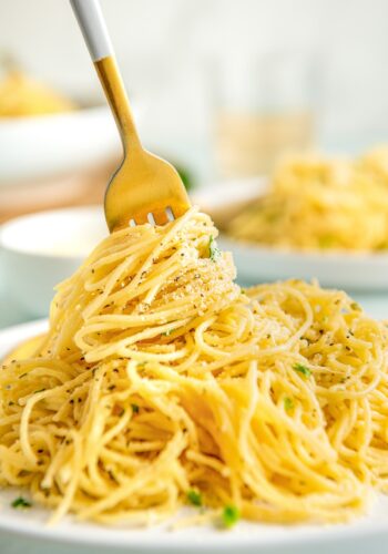 Parmesan pasta is being twirled by a fork.