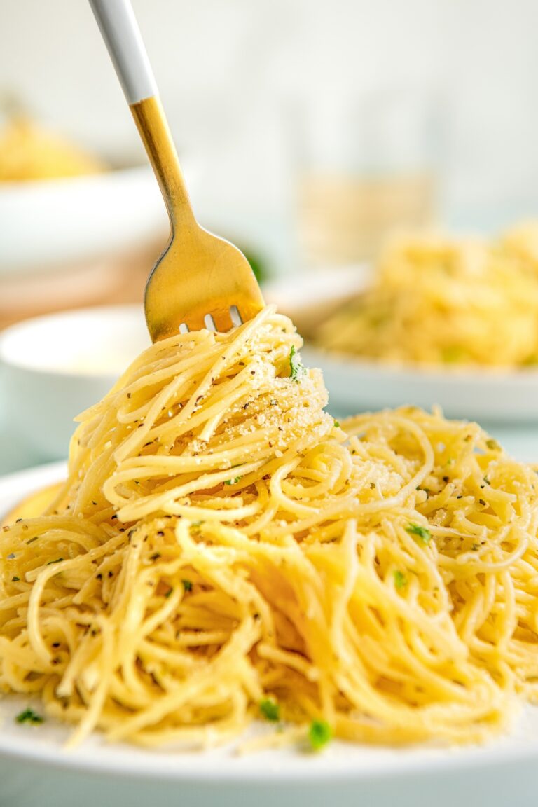 Parmesan pasta is being twirled by a fork.