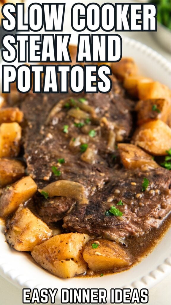 Slow cooker steak and potatoes presented on a large white plate.