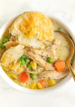 A spoon is placed in a bowl filled with creamy chicken pot pie soup.