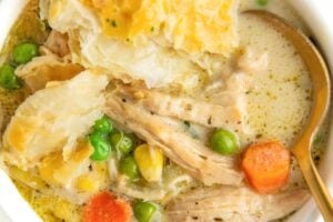 A spoon is placed in a bowl filled with creamy chicken pot pie soup.