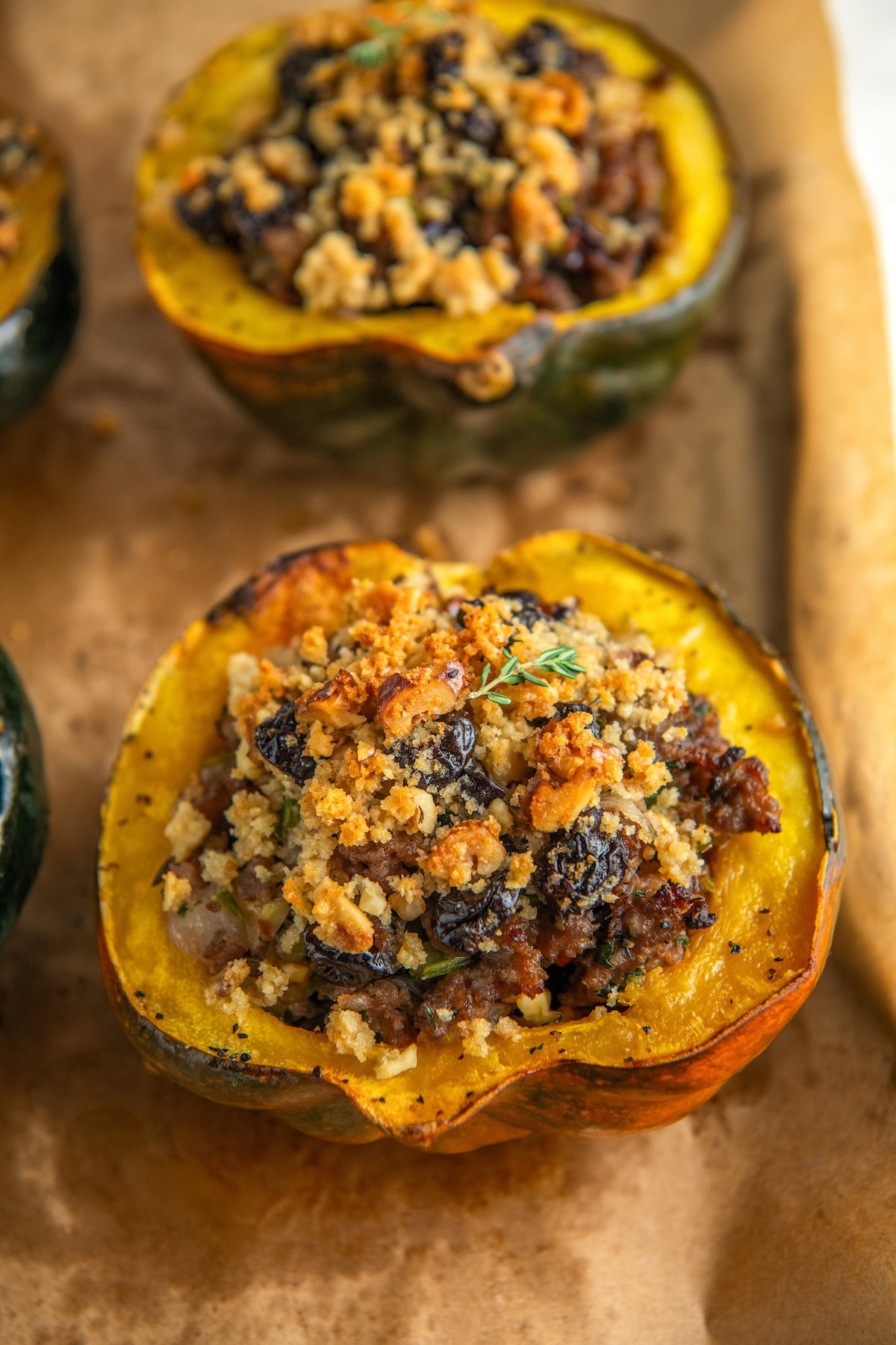 Baked acorn squash with sausage presented on a baking sheet.