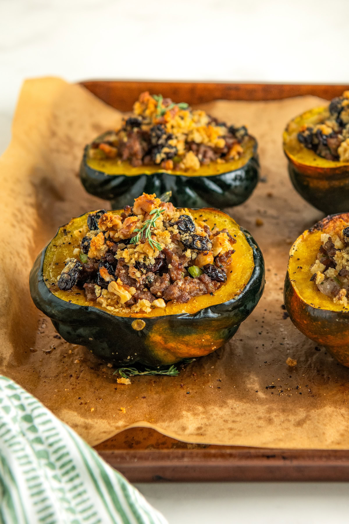 Sausage stuffed squash on a parchment paper lined baking sheet.