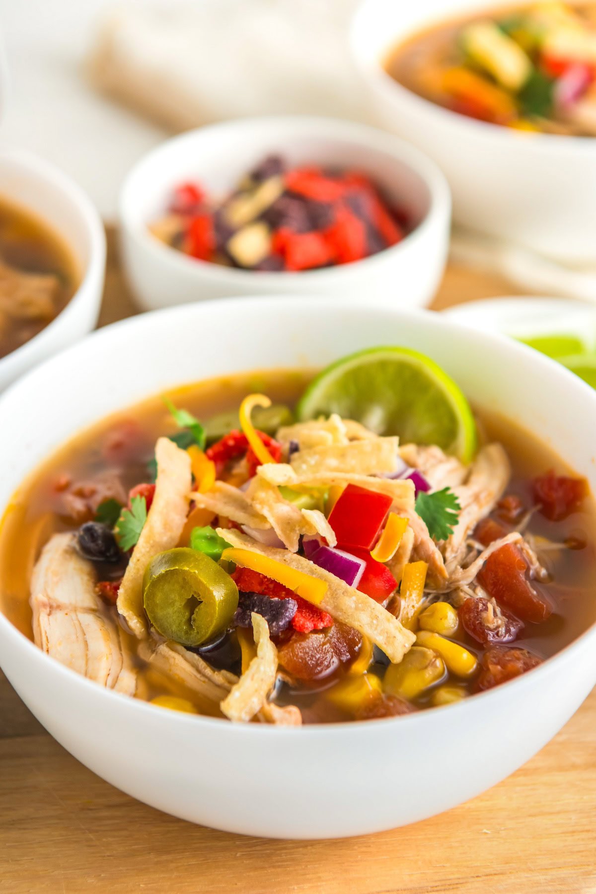 Tex Mex chicken soup topped with tortilla strips, cheese, and fresh veggies.