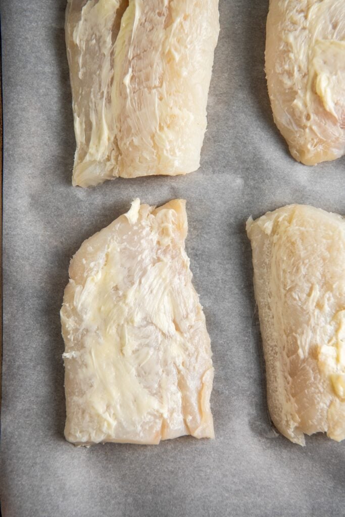 Raw fish filets are coated with lemon butter.