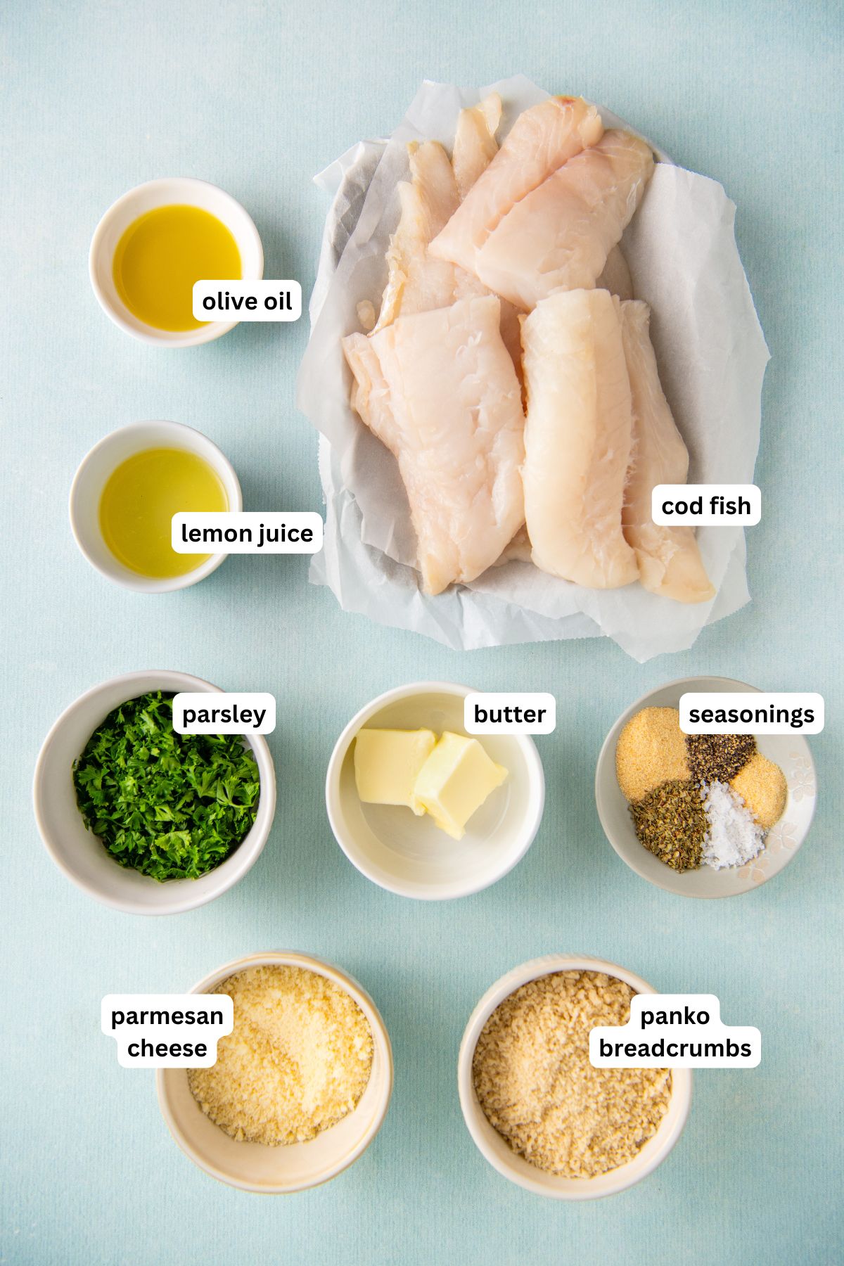 Ingredients for parmesan crusted cod recipe in order from top to bottom: olive oil, lemon juice, cod fish, parsley, butter, seasonings, parmesan cheese, panko breadcrumbs.