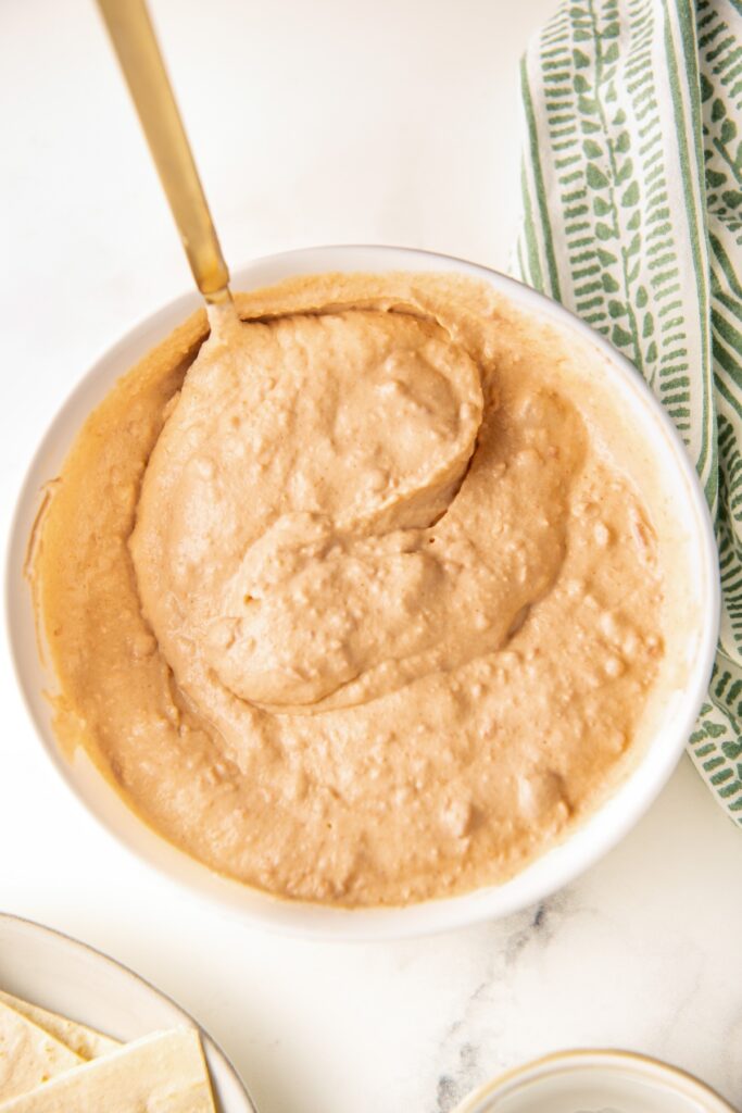 Creamy bean mixture in a large white mixing bowl.