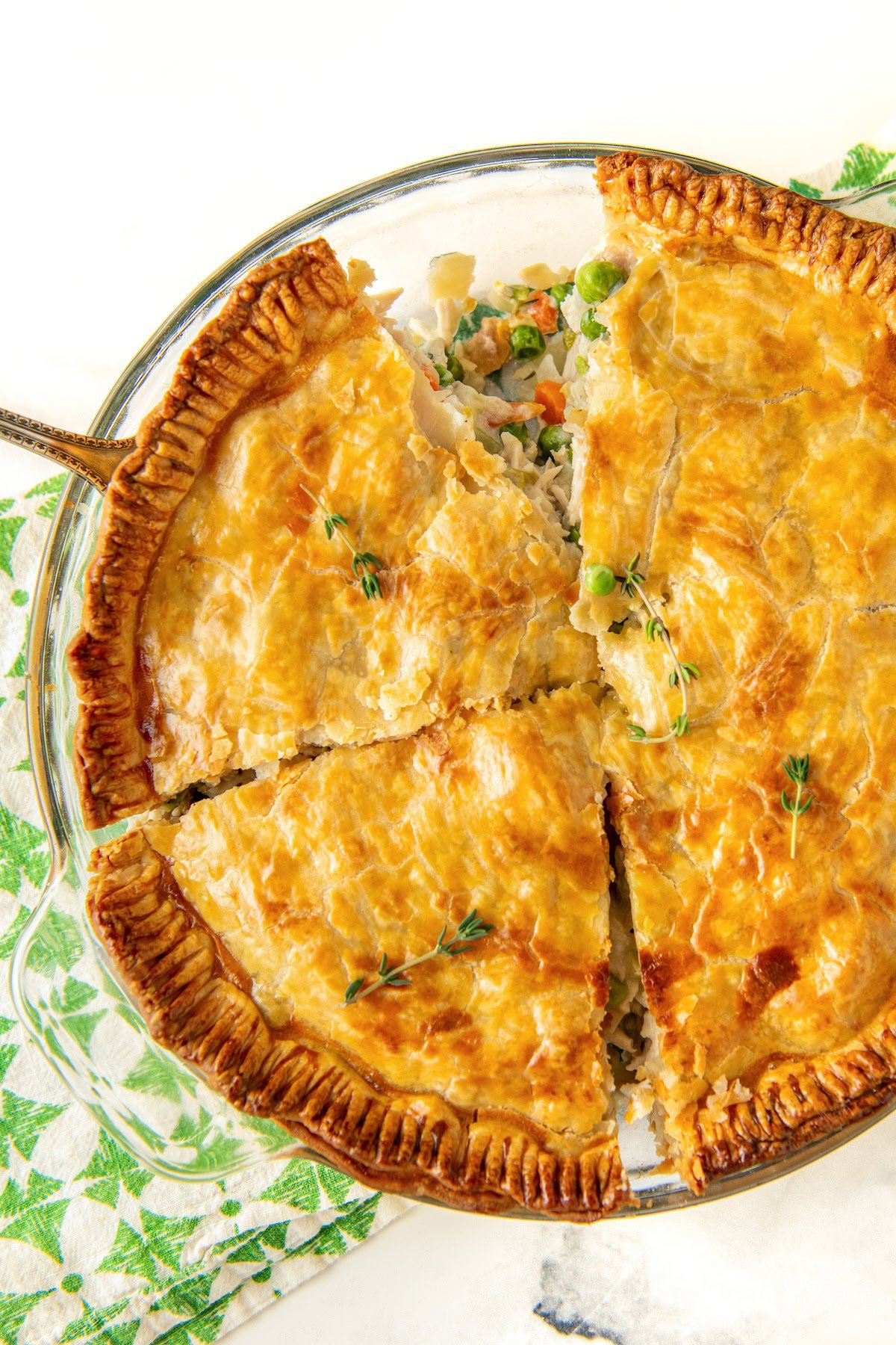 A hearty slice of chicken pot pie is being removed from the pie dish.