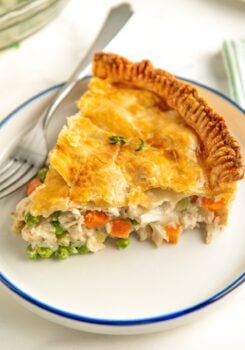 A thick slice of pot pie is presented on a round white plate.