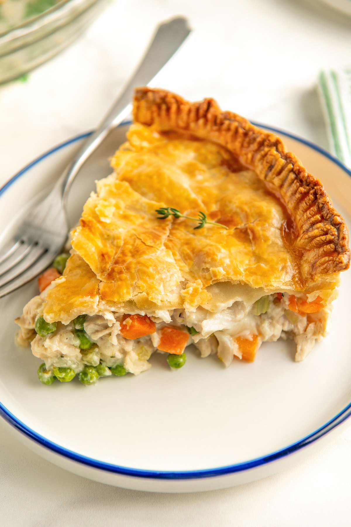 A thick slice of pot pie is presented on a round white plate.