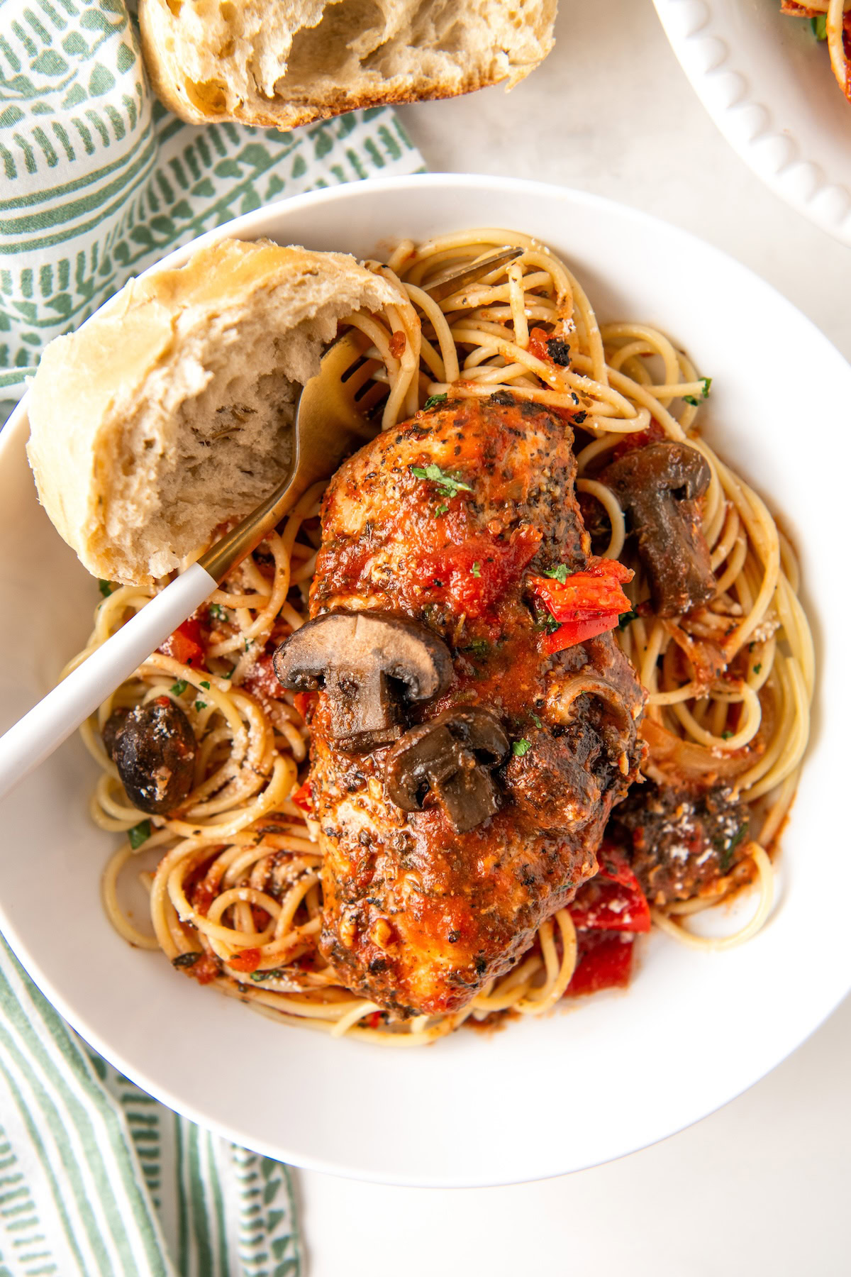 Italian chicken, vegetables, and pasta are plated together.