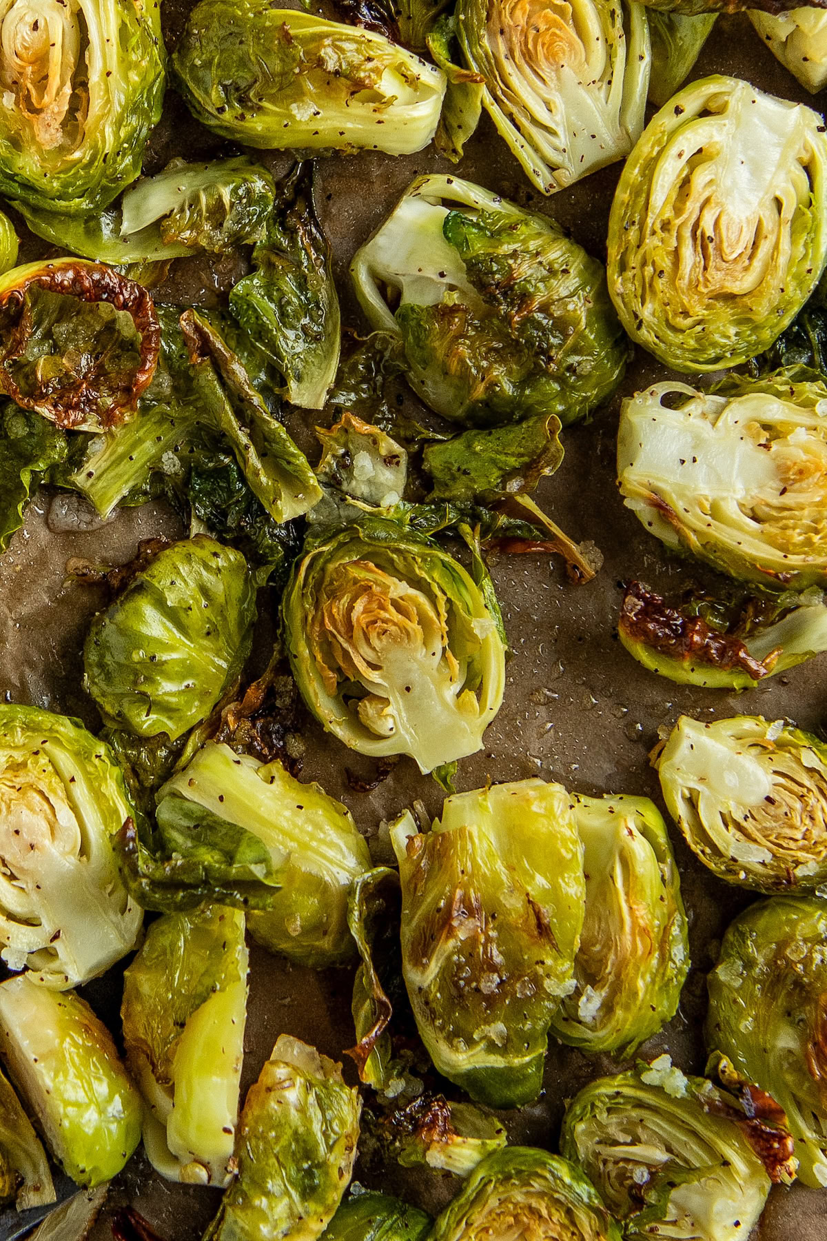 Oven baked Brussels sprouts arranged on a baking sheet lined with parchment paper.