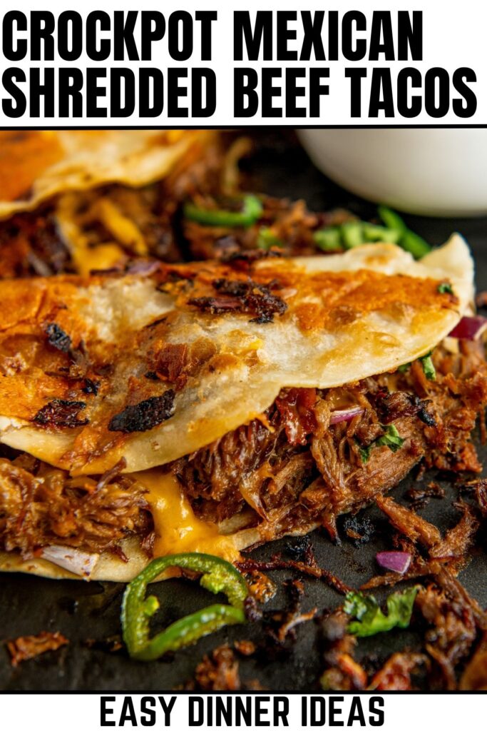 Close-up of crispy Mexican shredded beef tacos with melted cheese, garnished with sliced jalapeños and red onions.