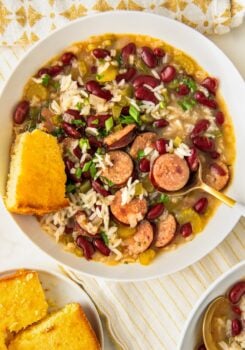 A slice of cornbread is served with a bowl of cajun soup.