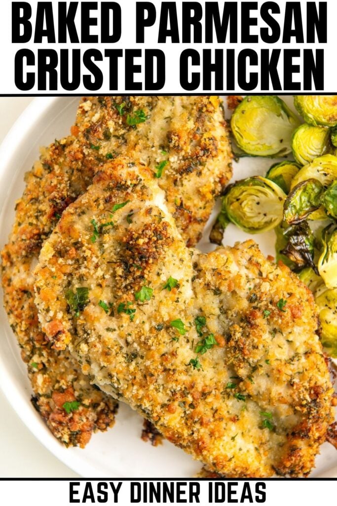 Baked parmesan crusted chicken presented on a plate next to roasted vegetables.