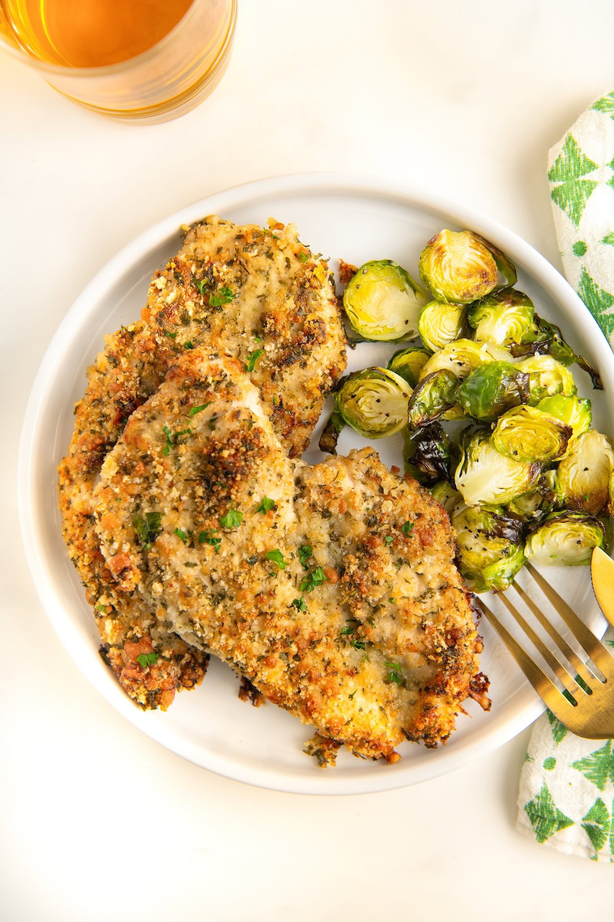 A plate is topped with crispy parmesan chicken and tender, roasted brussels sprouts.