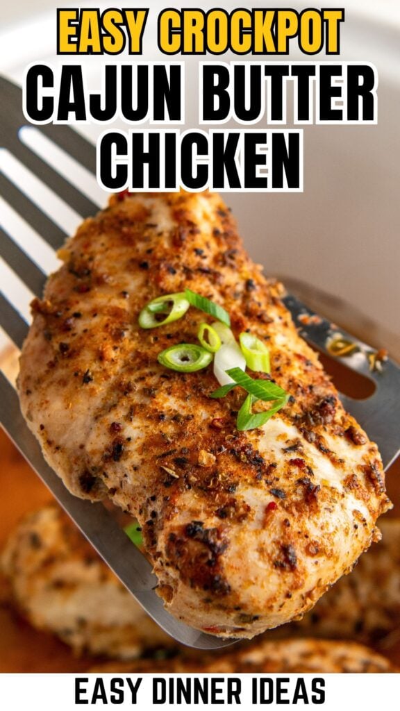 A close-up of a seasoned crockpot cajun butter chicken being lifted with a spatula, topped with sliced green onions.