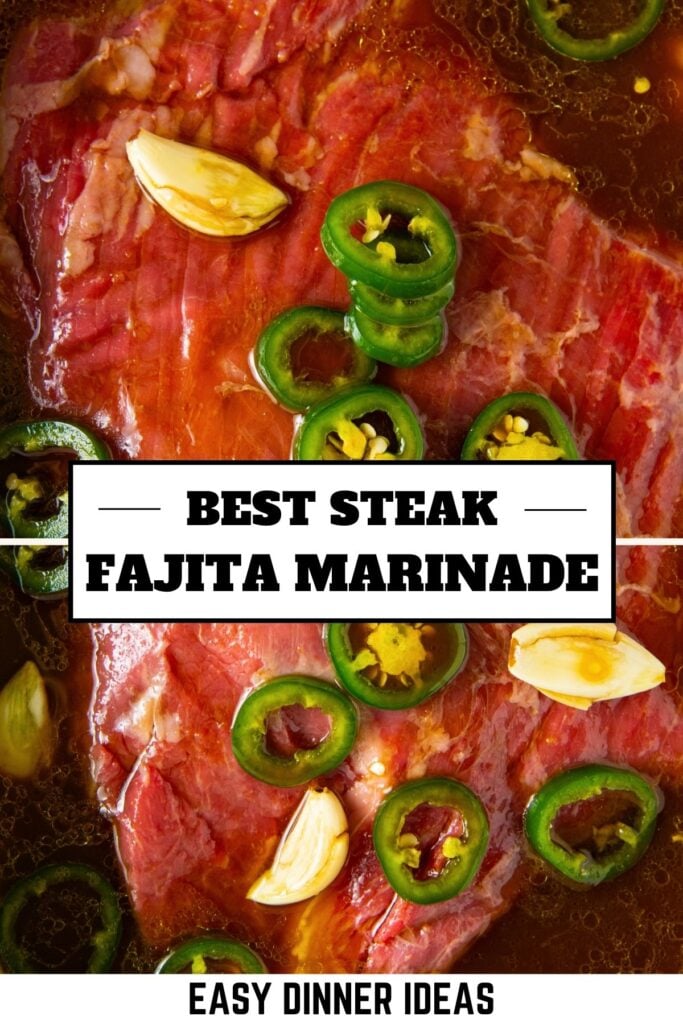 Raw steak marinating in a liquid fajita steak marinade mixture with sliced jalapeños and garlic cloves.