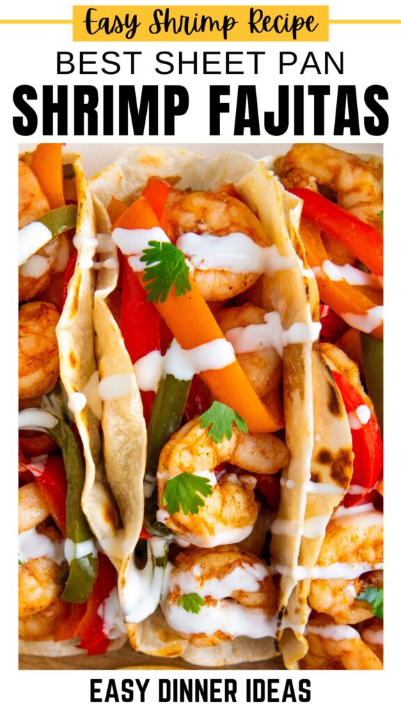 Close-up of shrimp fajitas in tortillas with red and green bell peppers, topped with white sauce and cilantro.