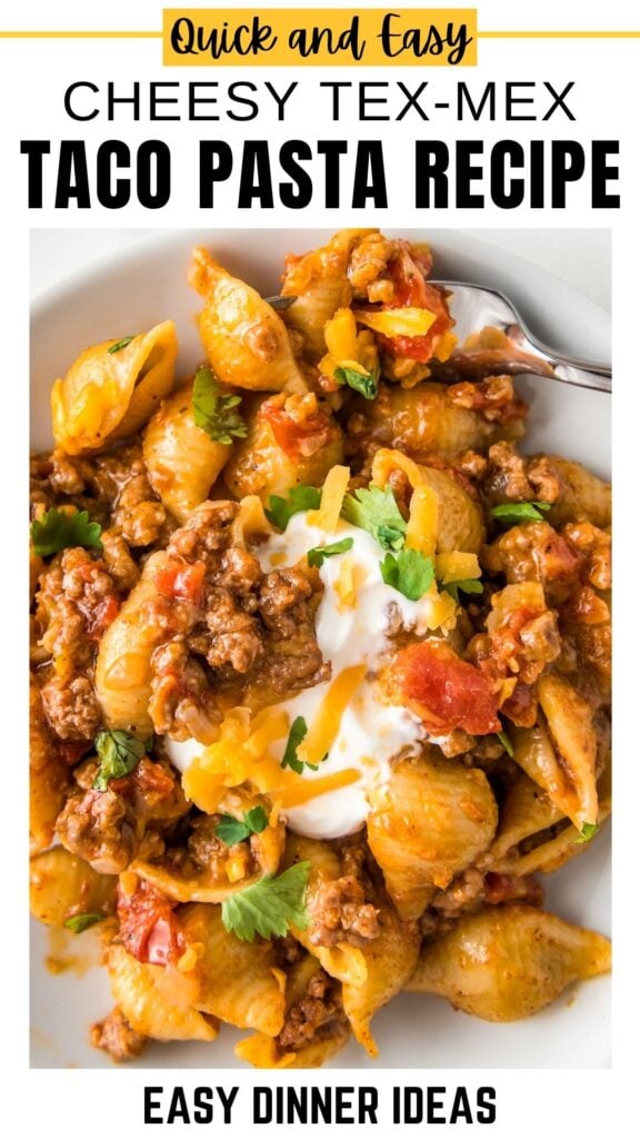 A plate of cheesy Tex-Mex taco pasta with ground beef, tomatoes, pasta shells, melted cheese, cilantro, and a dollop of sour cream.
