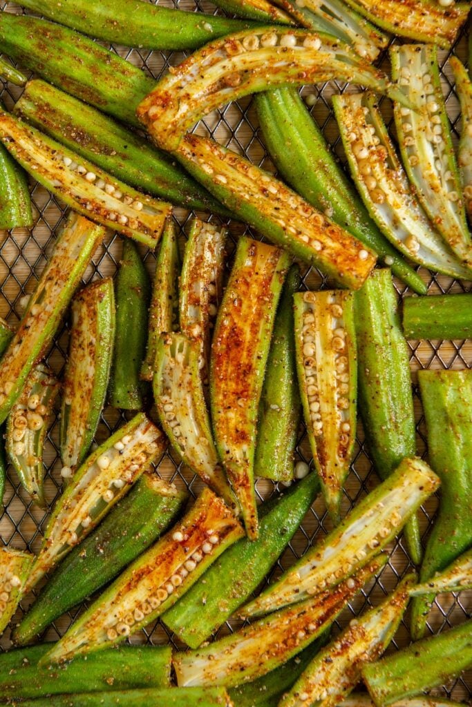 Slices of fresh okra coated with seasoning, arranged on a wire rack for air frying.