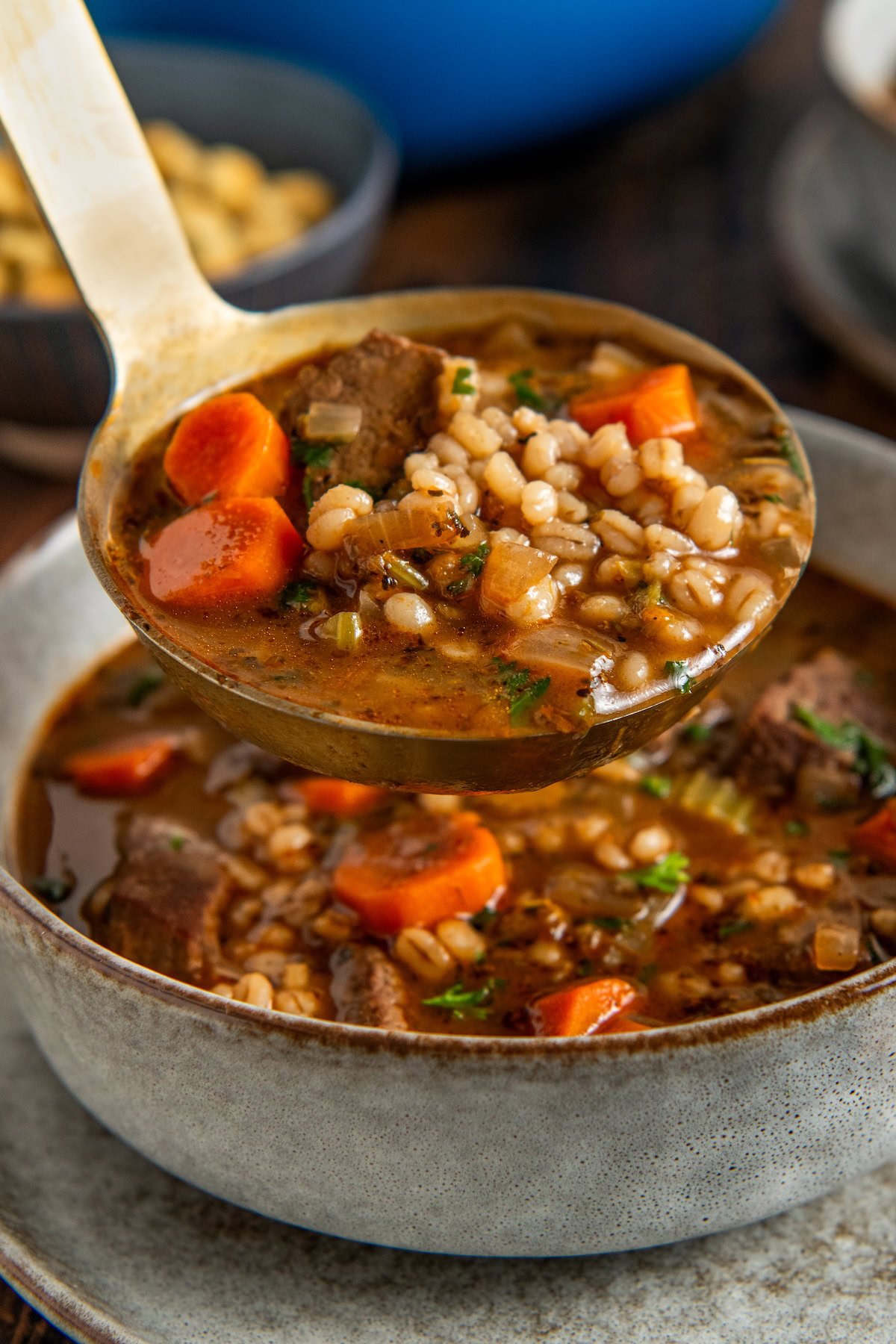 Made easy in one-pot, Beef Barley Soup is loaded with tender beef, chewy pearl barley, and lots of vegetables in a rich and savory broth. A ladle of beef barley soup with pieces of beef, barley, carrots, and herbs being served into a ceramic bowl.