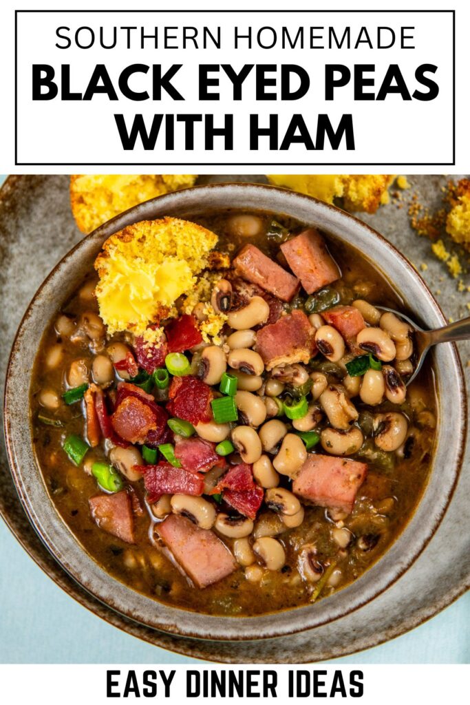 A bowl of black eyed peas with chunks of ham, garnished with green onions, served with a piece of cornbread on the side.